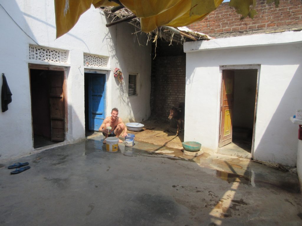 Taking my daily bucket shower next to the cows at Kuldeep’s home.