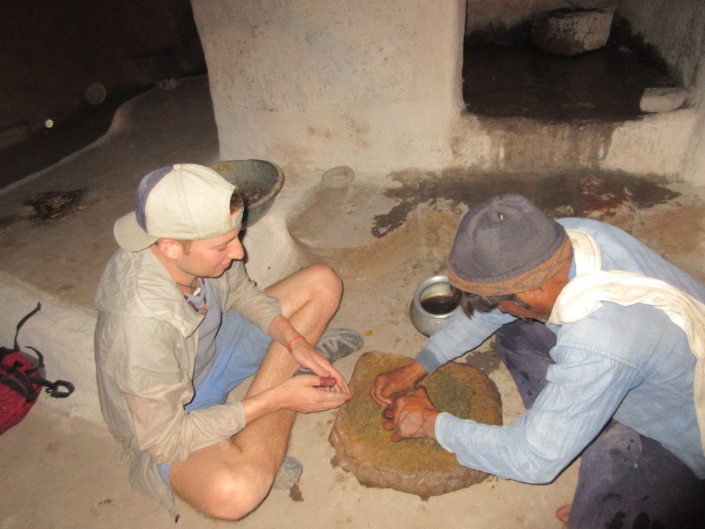 Grinding the bhang with the sweet herbs using stones.