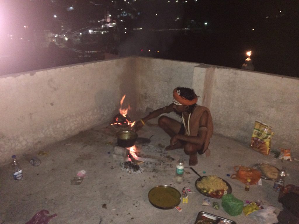 Adit Baba cooking over natural fire on the rooftop.